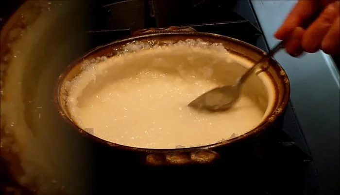 Use a spoon to spread some of the porridge onto the higher areas of the donabe to ensure even seasoning.