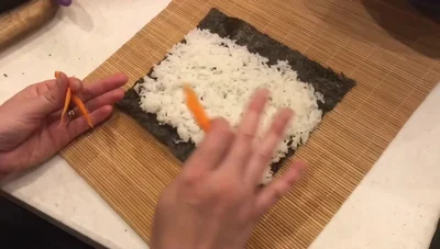 Place carrot slices (or other desired vegetables) on the rice.
