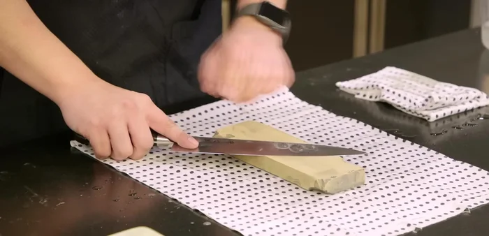 Establish the sharpening angle: Use the three-penny trick for the non-dominant side (backside), and the two-penny trick for the dominant side to set the angle. This ensures consistent angle throughout the process.