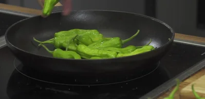 Prepare shishito peppers: Blister shishito peppers in a pan without oil.