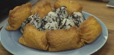 Assemble bento box: Arrange onigiri, inari, salmon, soy cured eggs, quick pickles, and fresh vegetables in your bento box.