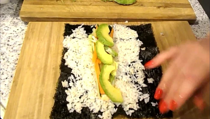 Moisten the top edge of the nori with a mixture of water and vinegar to help seal the roll.