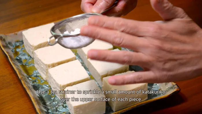 Lay tofu pieces on a tray. Sprinkle a small amount of katakuriko over the surface of each piece using a tea strainer.