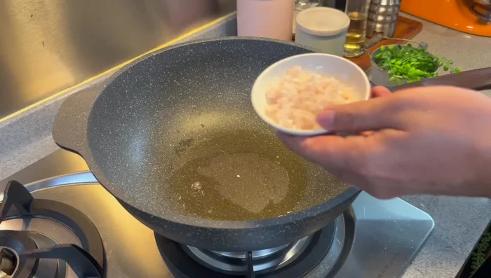 Add 2 chopped shallots to the same wok and stir-fry until fragrant.