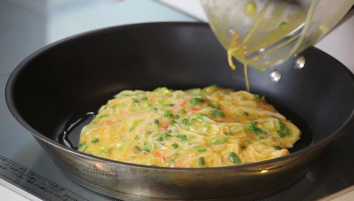 Pour egg mixture into the pan, forming a pancake.