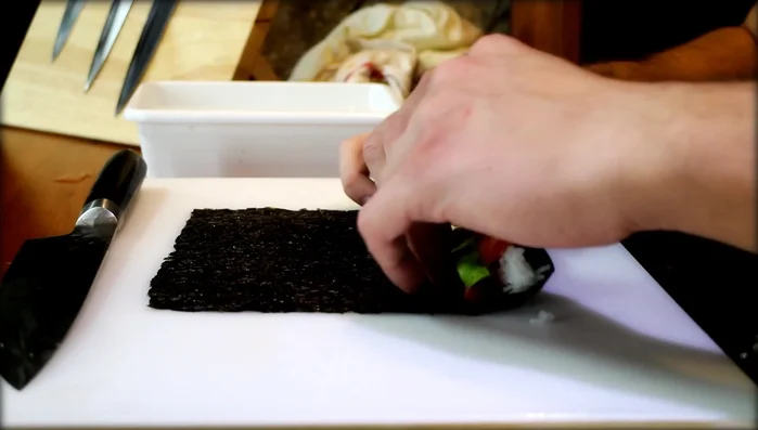 Gently lift the nori, keeping the filling together, and roll it tightly.