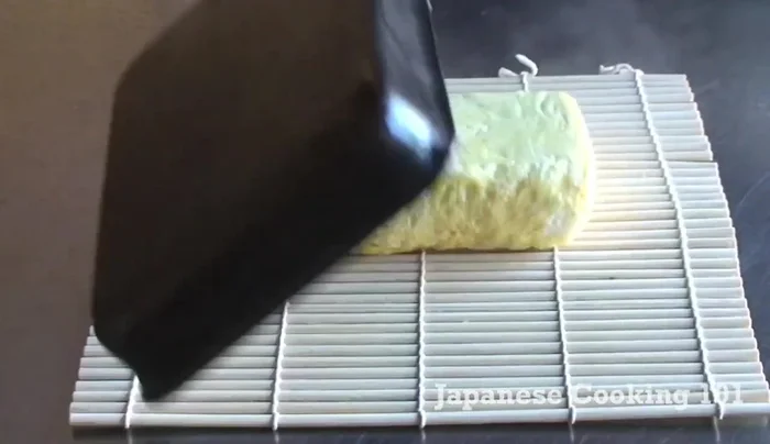 Transfer the rolled omelette to a sushi mat and roll it gently to create a tighter roll (optional).