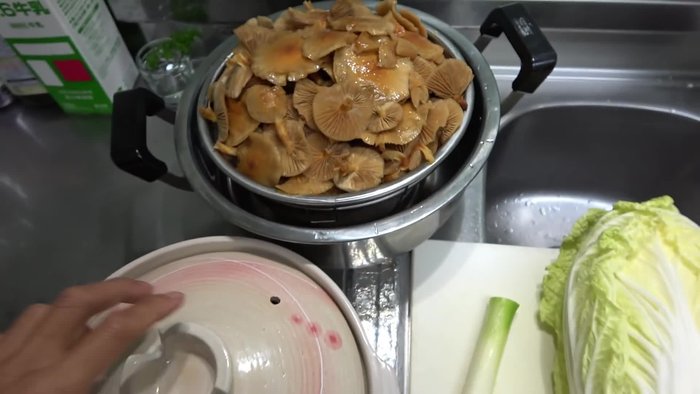 Place soaked nameko mushrooms in a pot. Add Chinese cabbage, green onions, and radish.