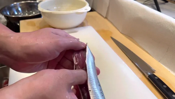 Insert 8 fingers from the middle of the sardine, towards the head. The flower (flesh) will open, revealing the bone.