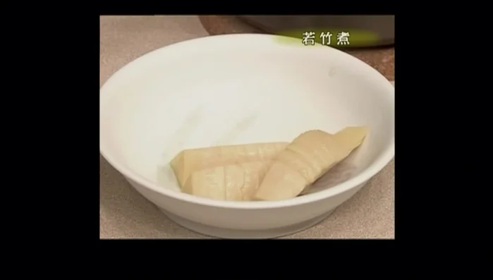 Arrange the simmered bamboo shoots and wakame. Garnish with spring fragrance wood (optional).