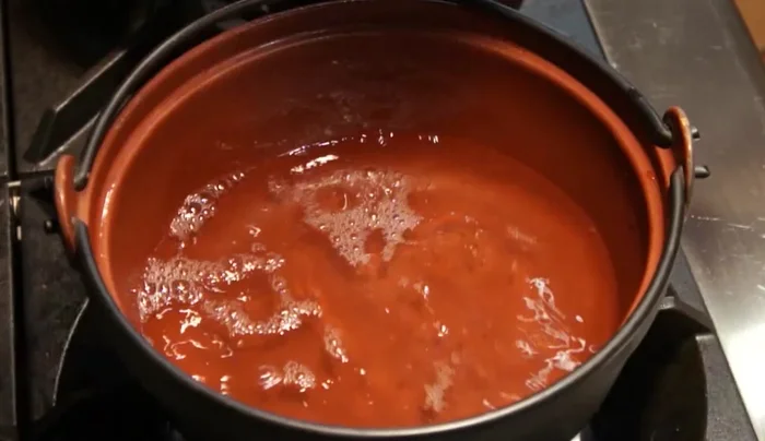 In a pot, combine 2 cups of dashi, minced garlic, sake, and soy sauce. Bring to a boil.