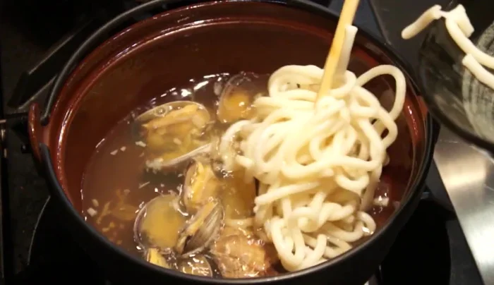 Add the cooked udon noodles to the broth.