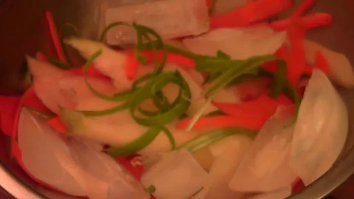 Peel and thinly slice daikon radish, carrot, and green onion using a vegetable peeler.