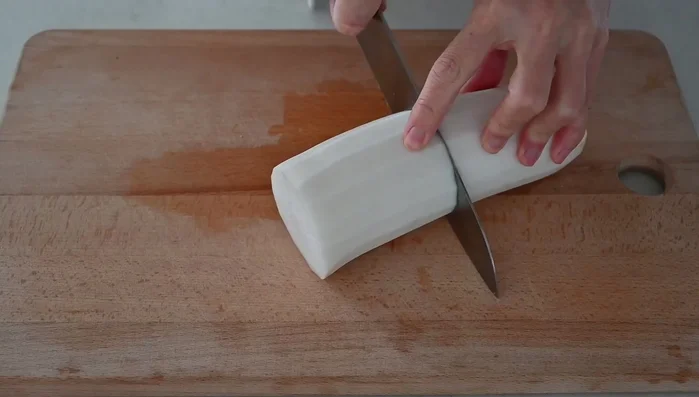 Peel and cut the daikon radish into 1.5 cm (1/2 inch) half-moon slices.