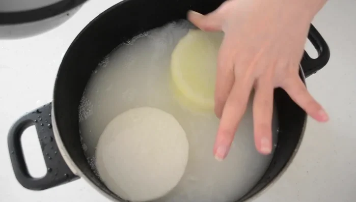 Pre-boil the daikon in rice rinsing water to remove bitterness and make it tender. Simmer for 10-15 minutes until translucent. Rinse under running water.