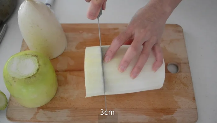 Peel the daikon and cut into 3cm thick slices. Score the surface crisscross to help it absorb dashi and become tender.