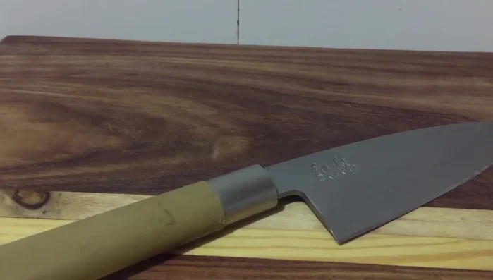 Single-edged kitchen knife on wood