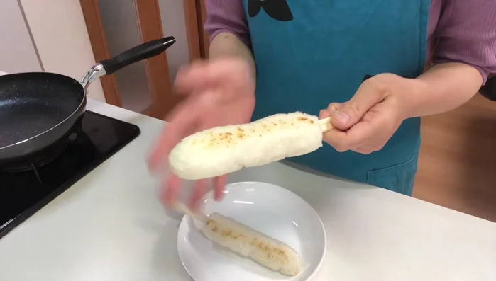 Remove Chopsticks: Remove the chopsticks from the kiritampo while still hot, gently rolling them to release them. Cut in half.