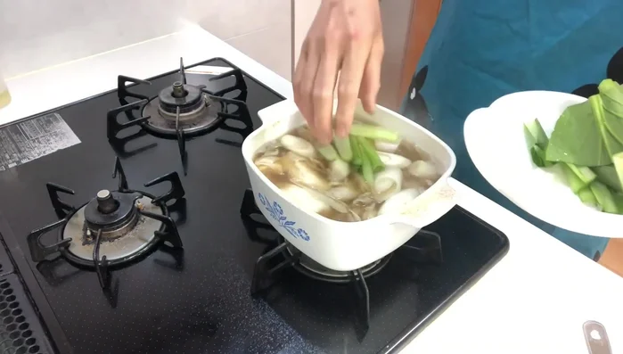 Add Komatsuna: Add komatsuna (stems first, then leaves) and simmer for a few more minutes.