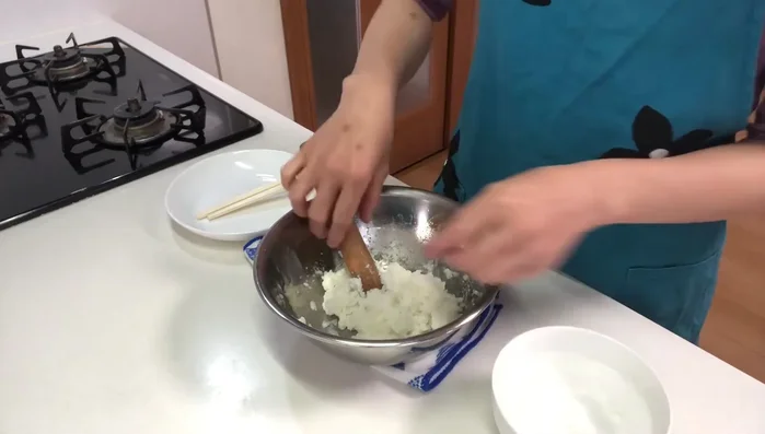 Shape the rice into balls with wet hands, pierce with chopsticks, and wrap the rice around them.