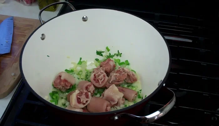 Add the prepared salted pigtails and chopped pimento peppers. Stir and cook on low heat for a few minutes to meld flavors.