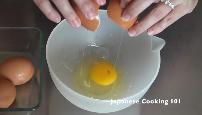 Crack 4 eggs into a bowl. Add salt, soy sauce, and mirin. Mix well.