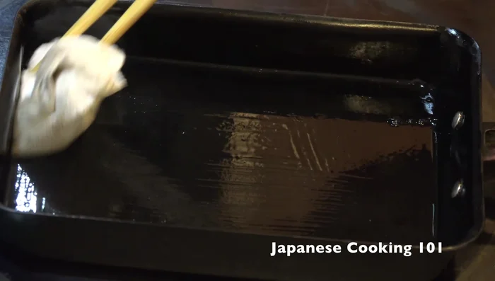 Pour a thin layer of egg mixture into the pan. Tilt the pan to spread the egg evenly. Let it set slightly.