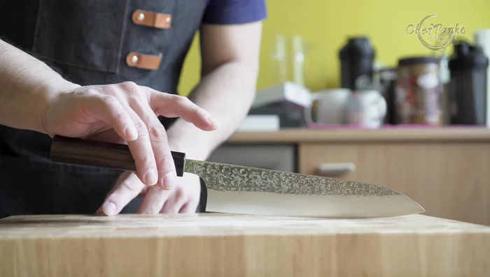 Santoku knife with wooden handle on board