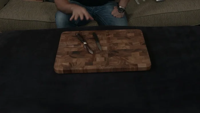 Two knives on wooden cutting board