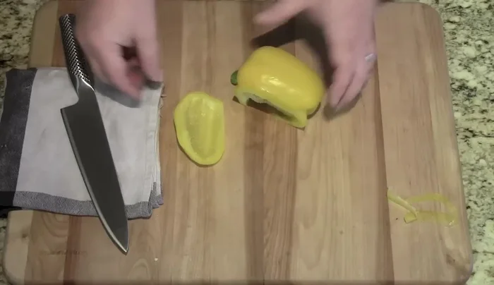 Sharp knife slicing yellow pepper