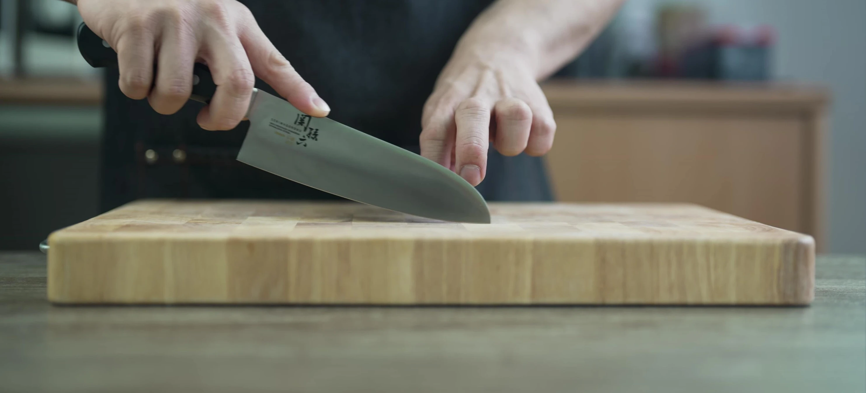 Stainless steel knife cutting on wood board