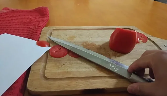Kai Wasabi Yanagiba knife slicing tomato