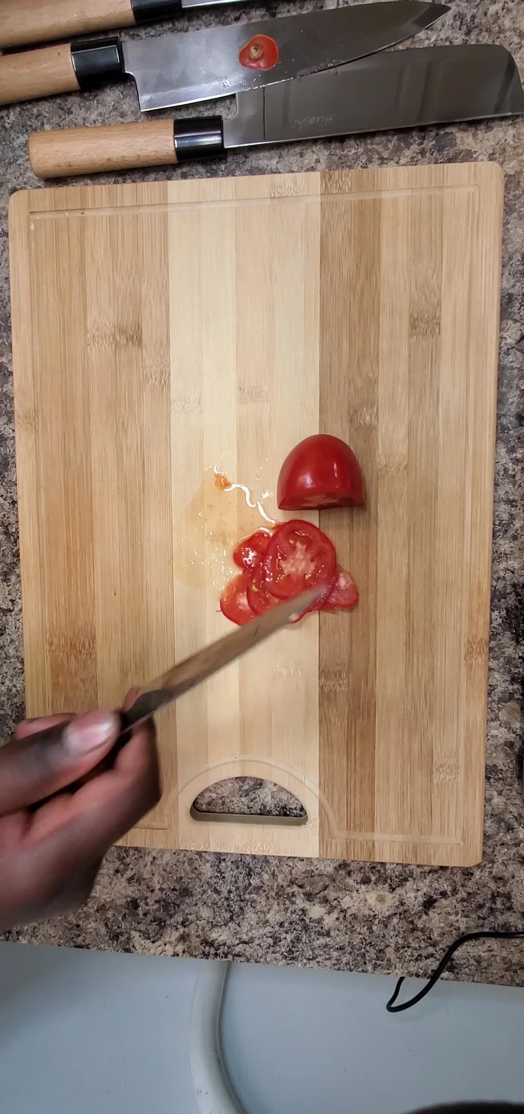 Sharp knife slicing tomato cleanly.