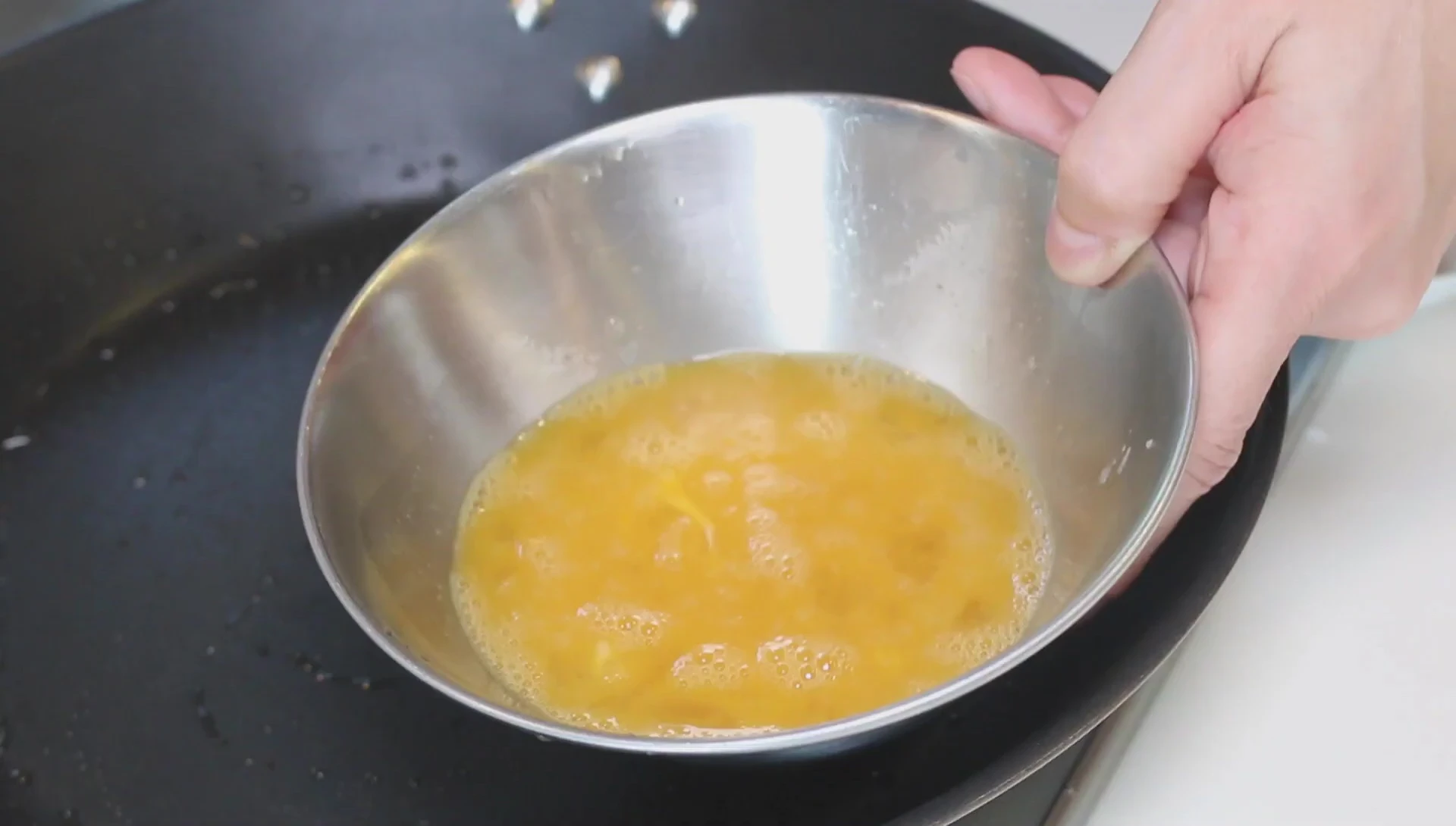 Whisk egg mixture in metal bowl.
