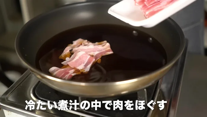Add the pork belly to the cold pan and break it apart to prevent hardening.
