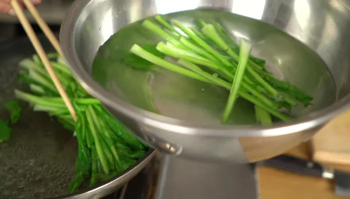 Remove the leaves and immediately plunge them into cold water. Squeeze out excess water gently, avoiding making them soggy.