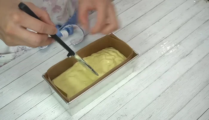 Prepare the pound cake mold (line with parchment paper). Pour the batter into the mold, level the surface, and place the reserved chestnuts on top. Press down gently. Make a small cut in the center.