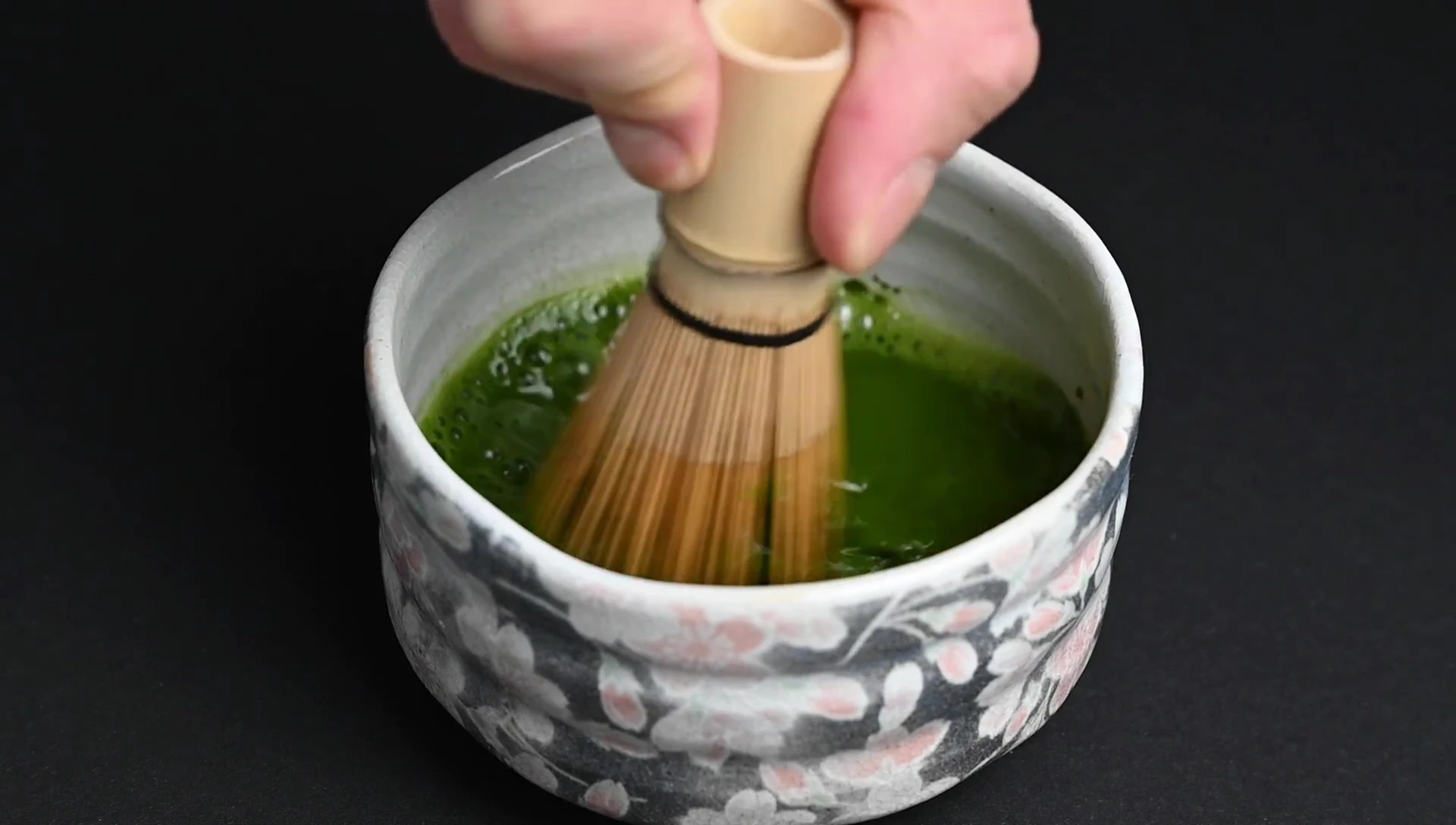 Whisking matcha tea in a bowl