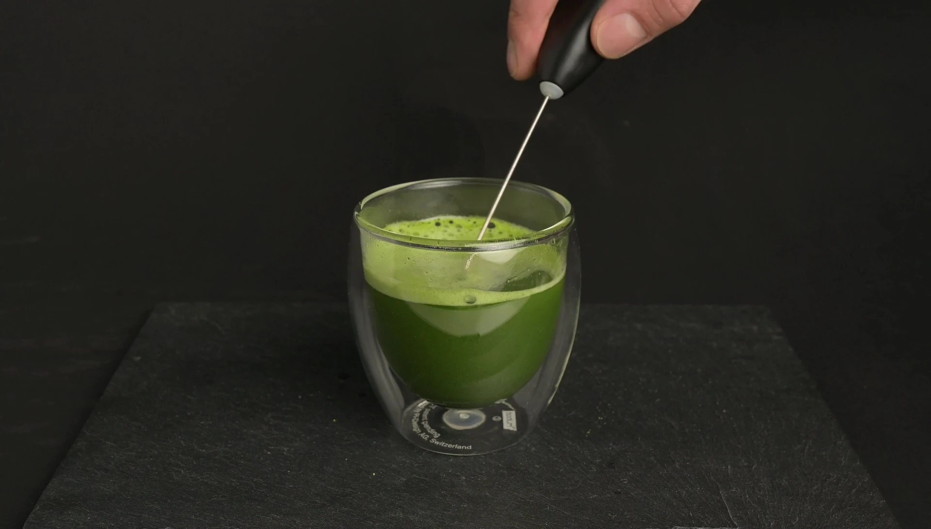 Matcha whisk frothing in glass