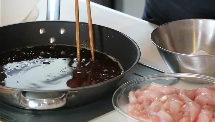 Dust chicken with potato starch. Check oil temperature with chopsticks (small bubbles form around chopsticks when it's ready).
