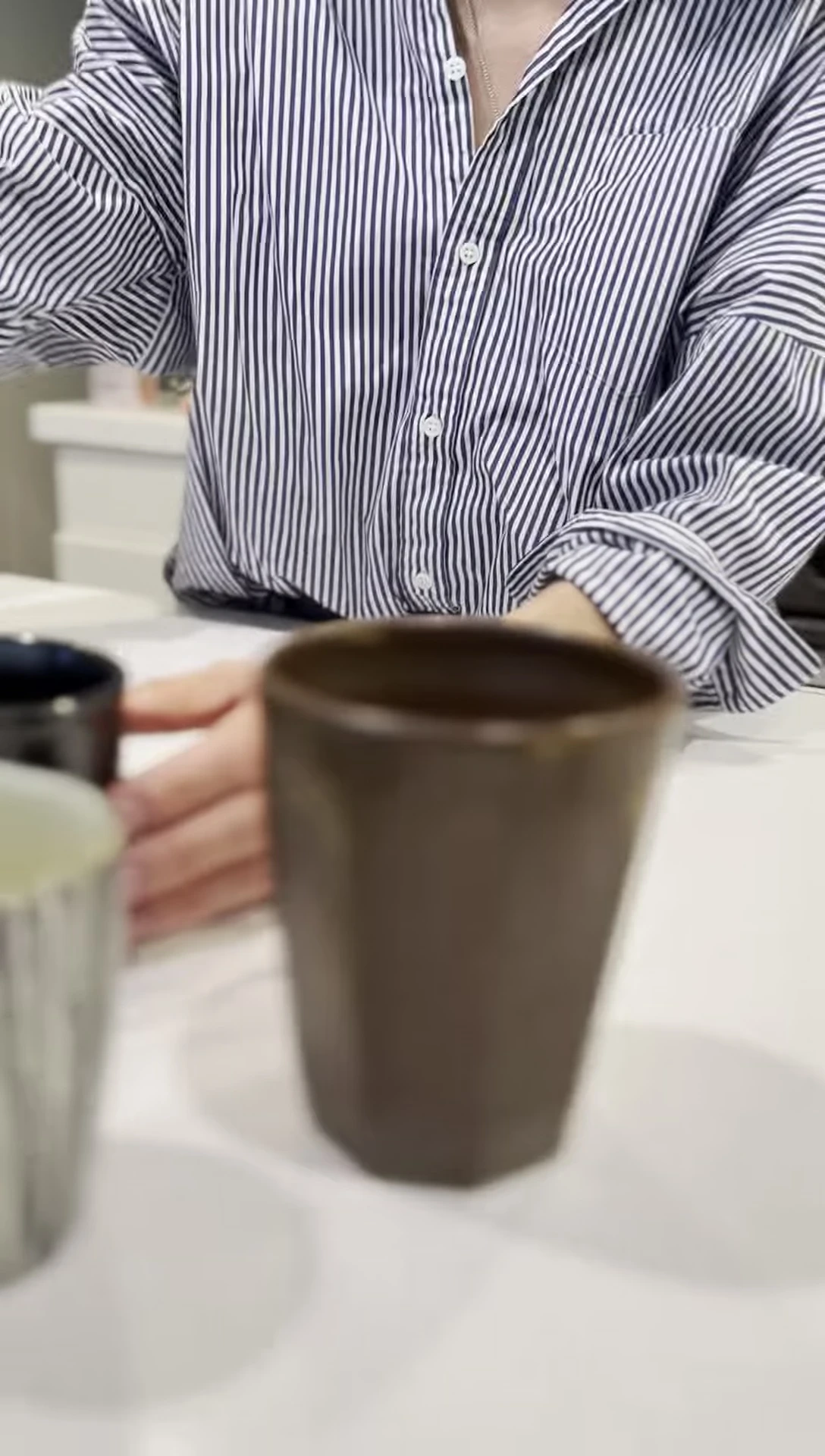 Person holding handmade ceramic cups