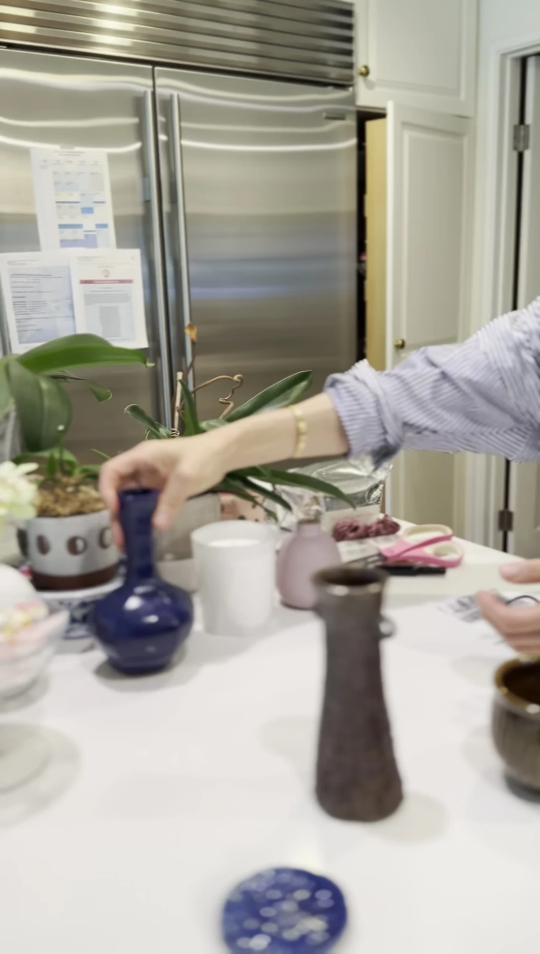 Person arranging Japanese pottery and vases
