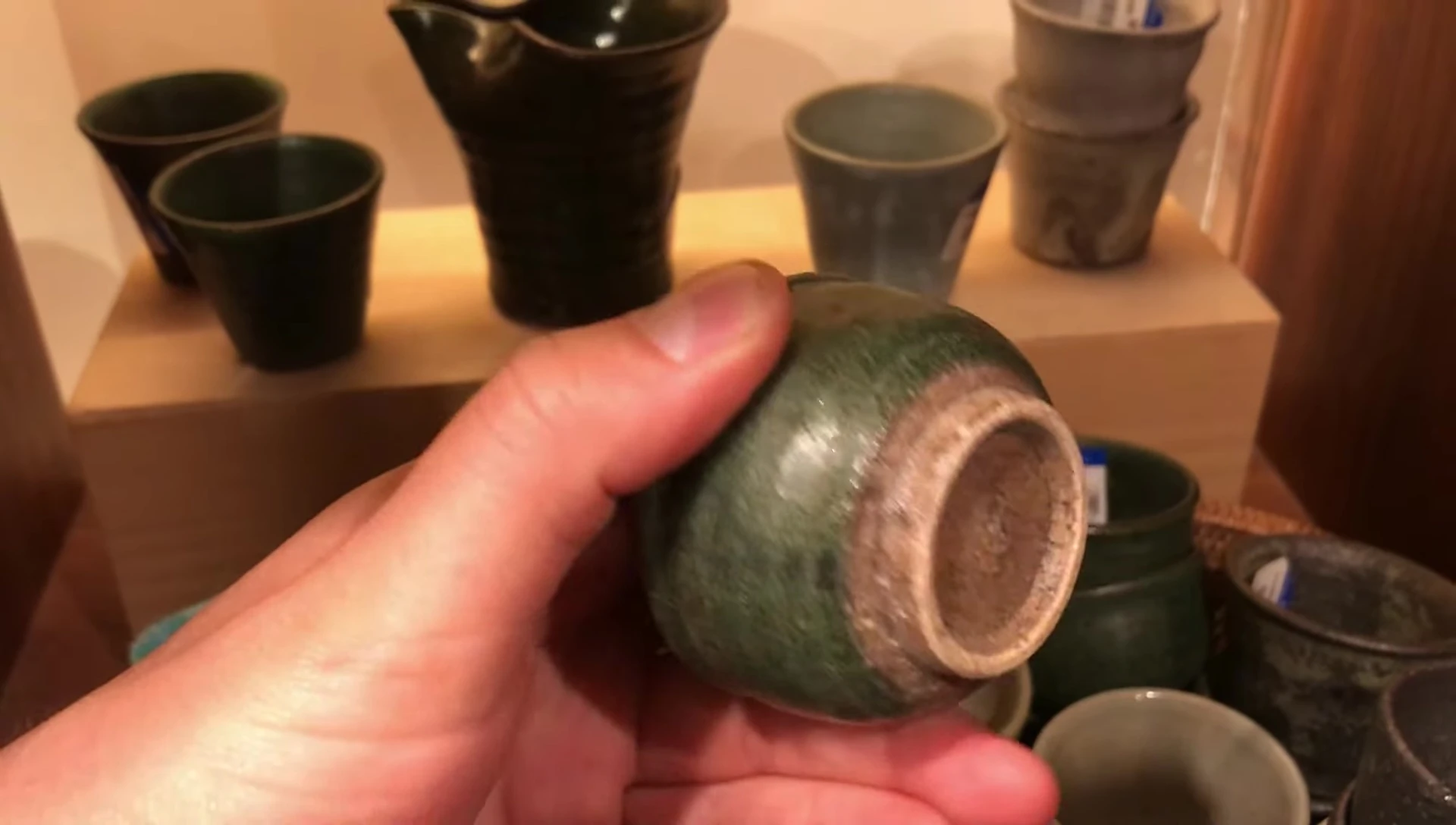 Hand holding traditional Japanese teacup