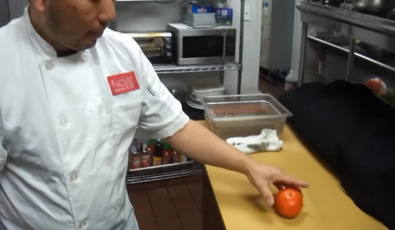 Sharp knife slicing tomato cleanly