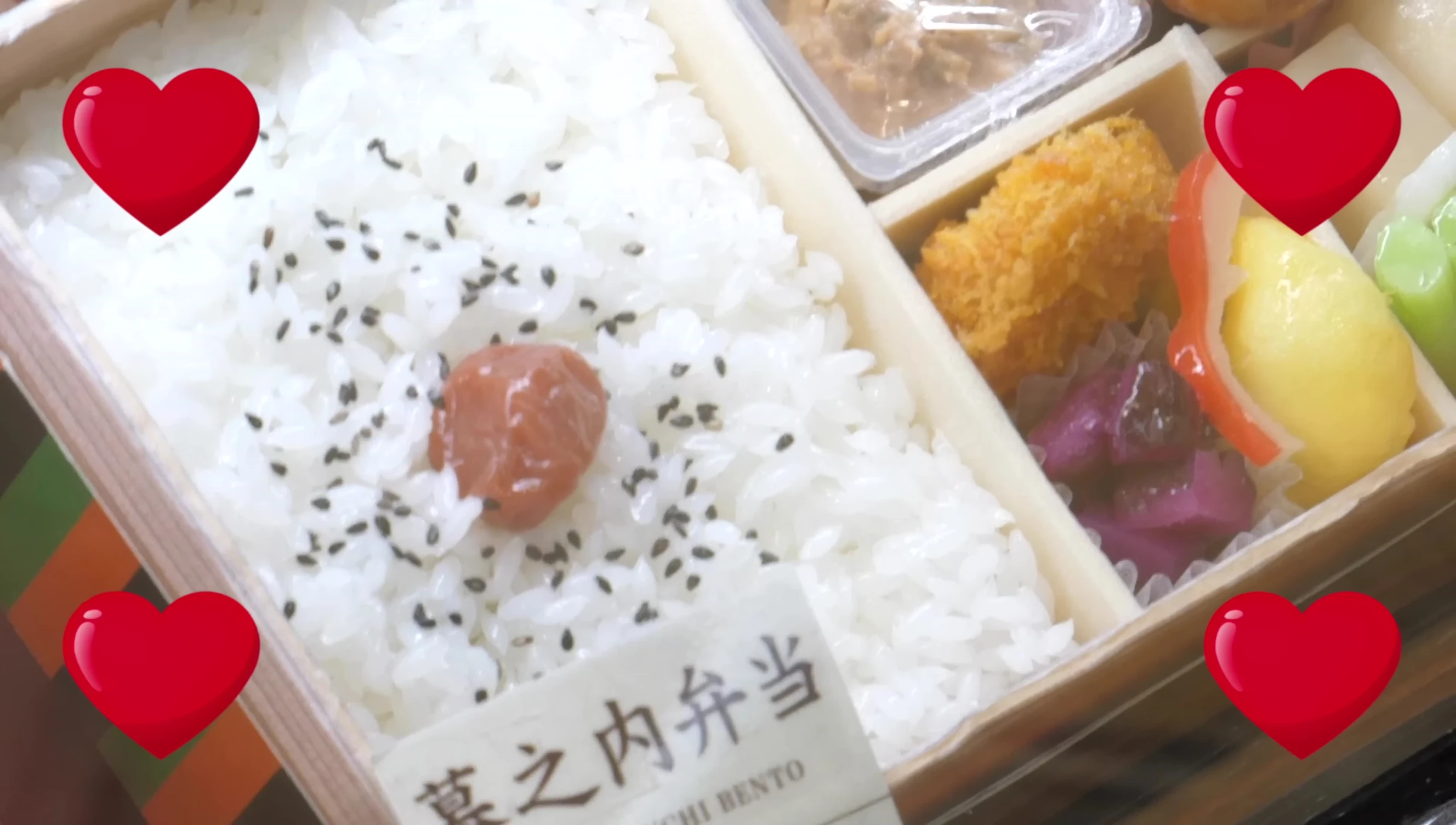 A bento box featuring a large portion of rice and pickled plum.