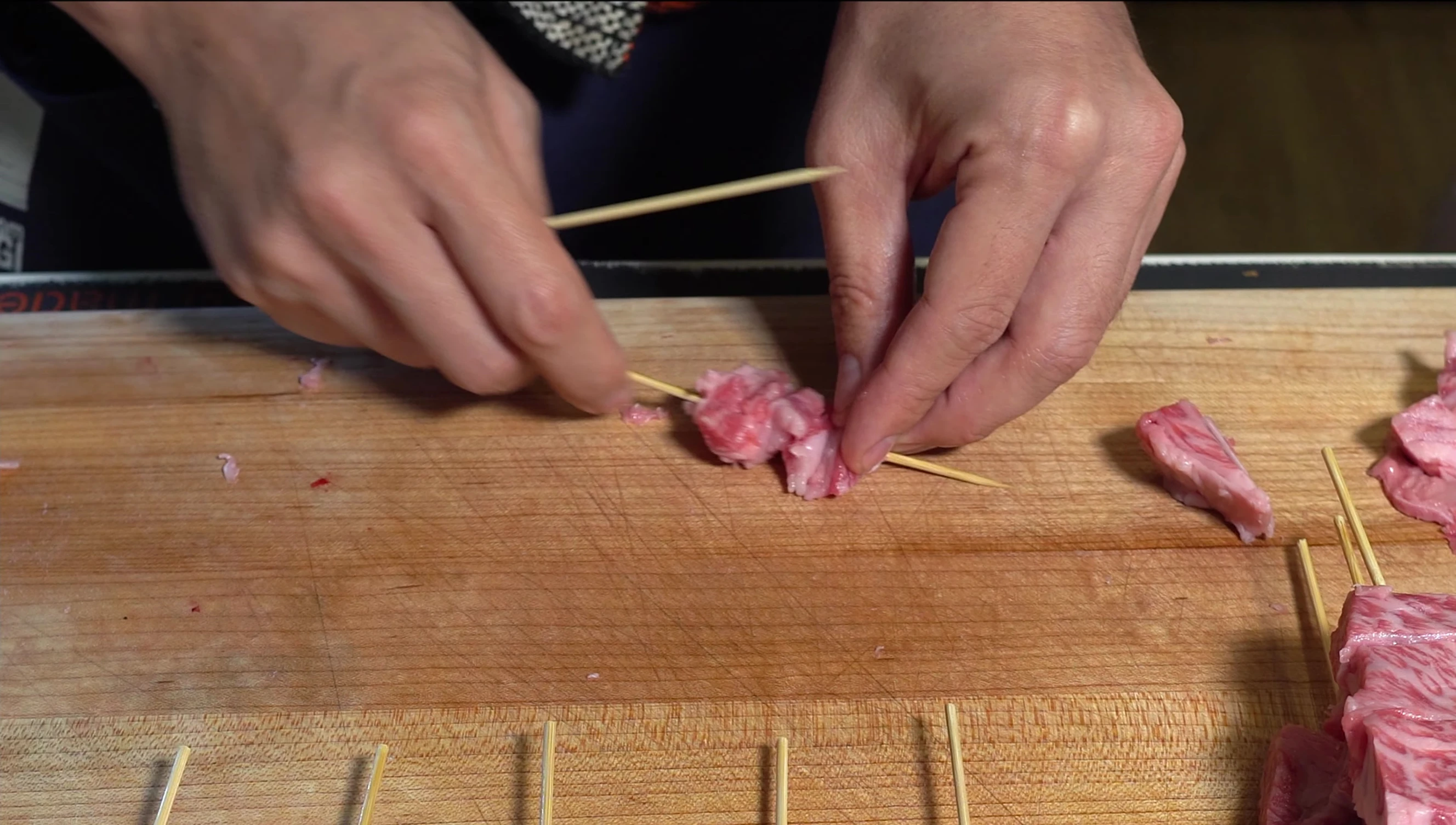 Wagyu beef being skewered for yakitori.