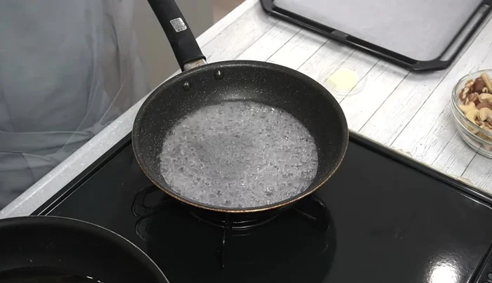 Once the sugar starts to boil and change color (around 2 minutes), gently shake the pan to distribute the color evenly. Be cautious of smoke and use an exhaust fan.