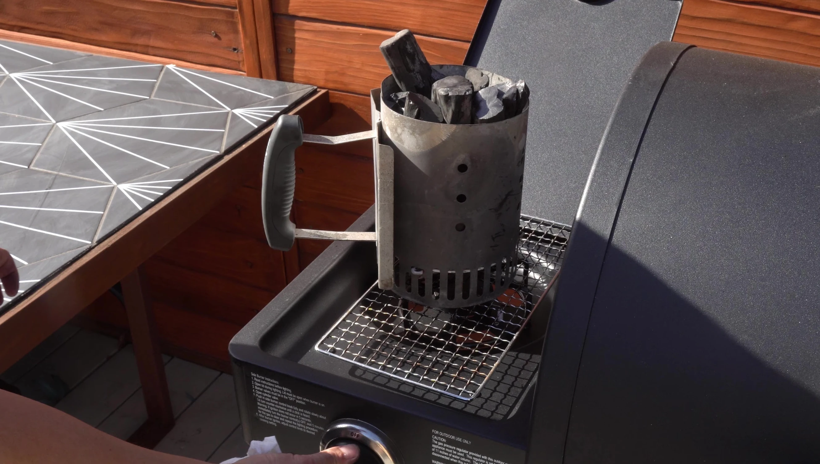 Safely lighting Binchotan charcoal using a chimney starter.