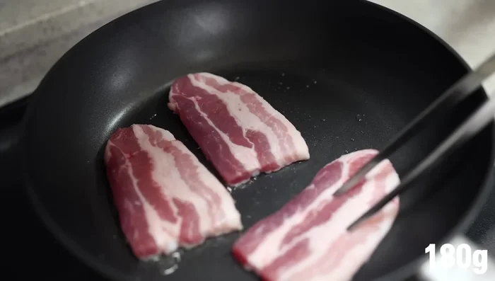 Cook chashu: Heat oil in a pan. Add thinly sliced pork belly and cook until done. Pour chashu sauce over pork and cook for 3 minutes. Use a blow torch for smoky flavor (optional).