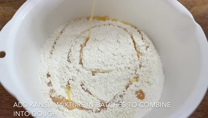 Ladle hot broth over noodles.